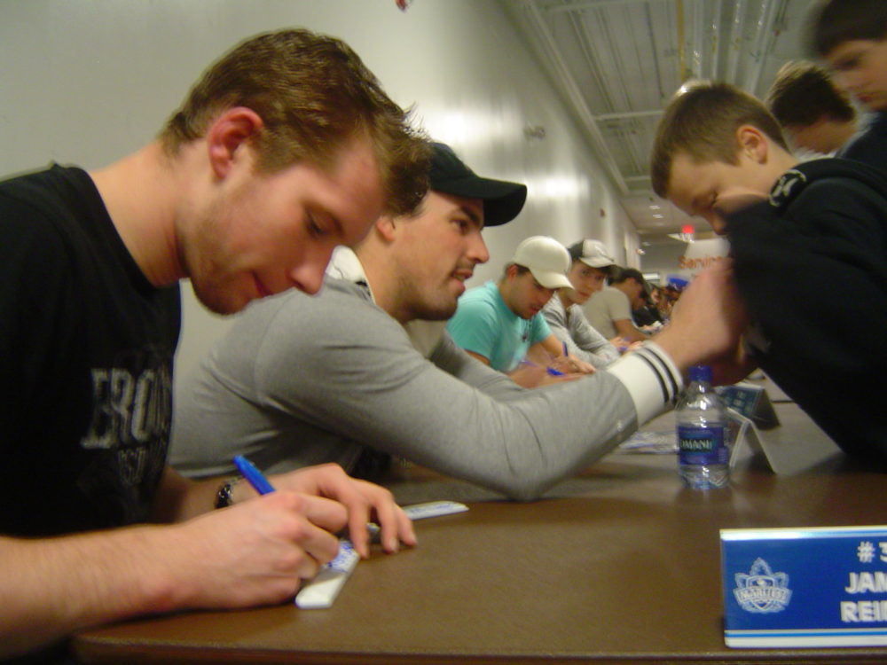 Goalies Reimer and MacDonald sign autographs for a long line of excited hockey fans.