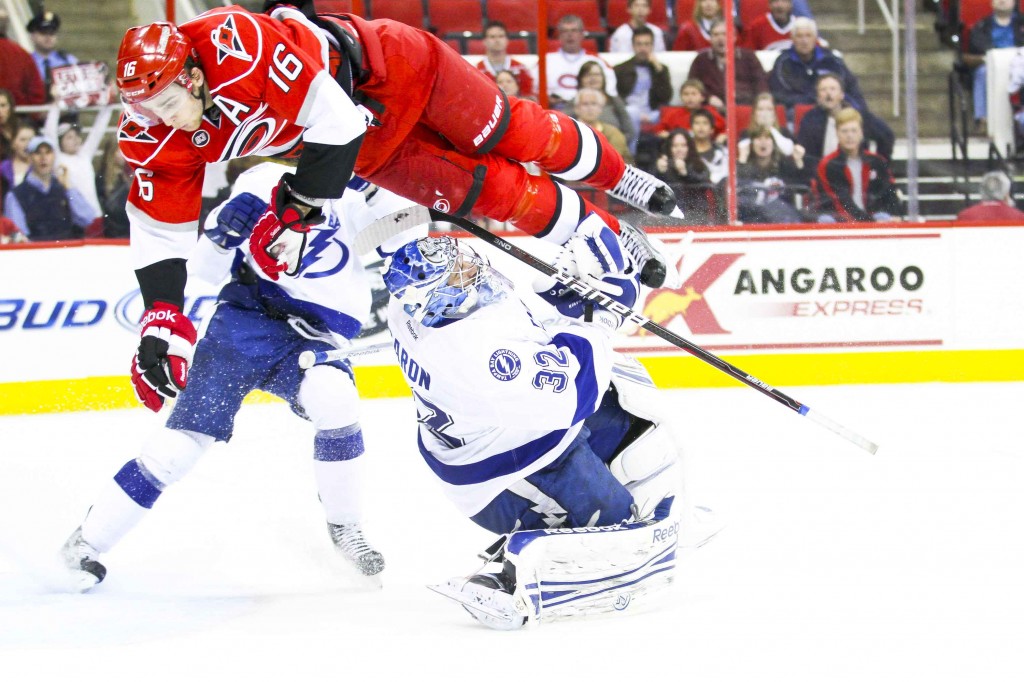 Carolina Hurricane Brandon Sutter (16) airborne over Tampa Bay Lightning goalie Mathieu Garon (Andy Martin Jr)