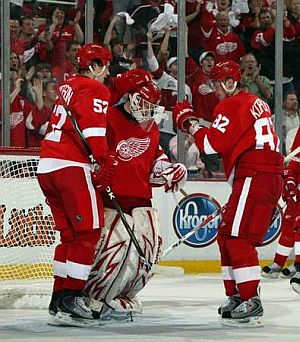 Detroit Red Wings Jonathan Ericsson and Tomas Kopecky congratulate goalie Chris Osgood aftger his 4-0 shutout win over Columbus in game 2 on Saturday April 18. (JULIAN H. GONZALEZ/DFP)