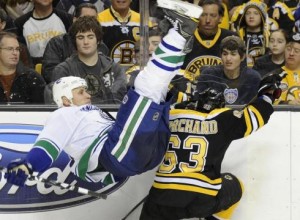 Brad Marchand upends Sami Salo durign Saturday's game. Marchand is facing a suspension for the clip, which appaered to be just above Salo's knee. (Boston Herald)