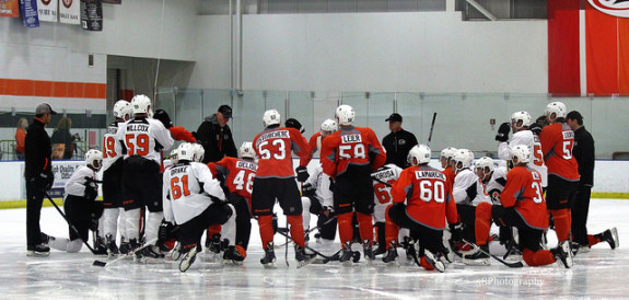 Flyers prospect huddle around the coach at development camp. [Photo: Amy Irvin]