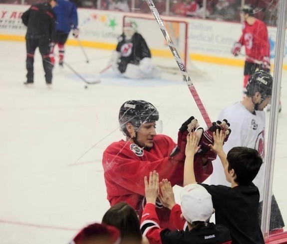 Damien Brunner high-fives a young fan through the glass at an open practice for season ticket holders (Photo by June Glinowiecki Toth)