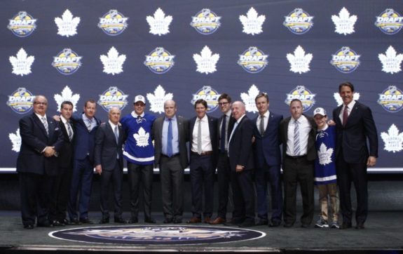 Auston Matthews linked arm and arm with the Toronto Maple Leafs' management team pose for a picture after drafting Auston Matthews first overall in the 2016 NHL Entry Draft.