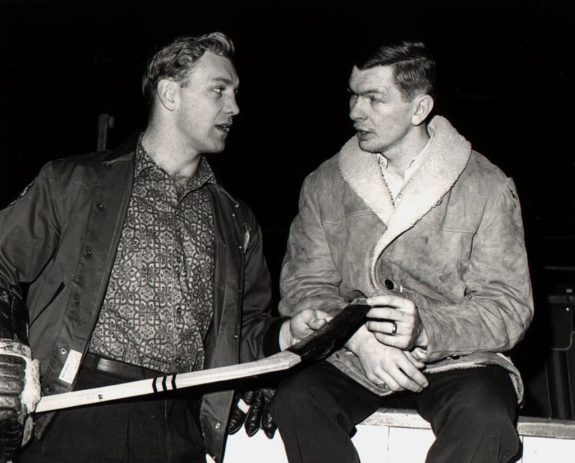 Bobby Hull #9 holds a hockey stick as he talks to teammate Stan Mikita - best duos in NHL history