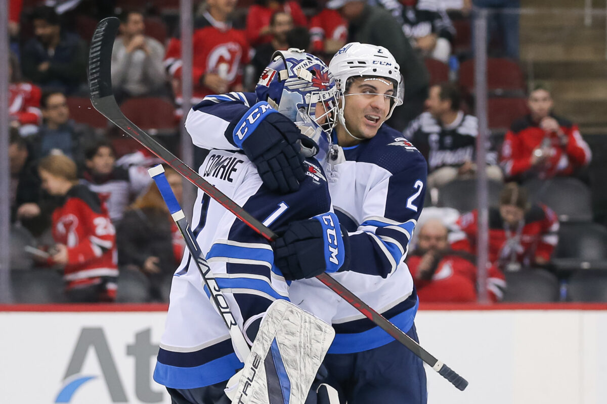Dylan DeMelo celebrates with Eric Comrie Winnipeg Jets